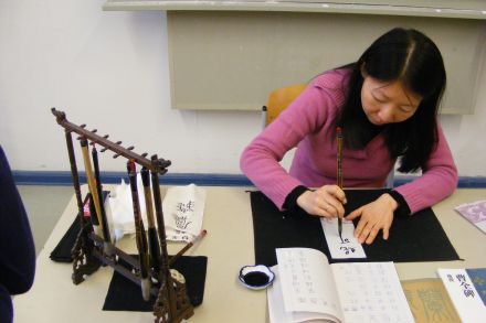 In einem Klassenraum wurde das Malen von chinesischen Zeichen angeboten.